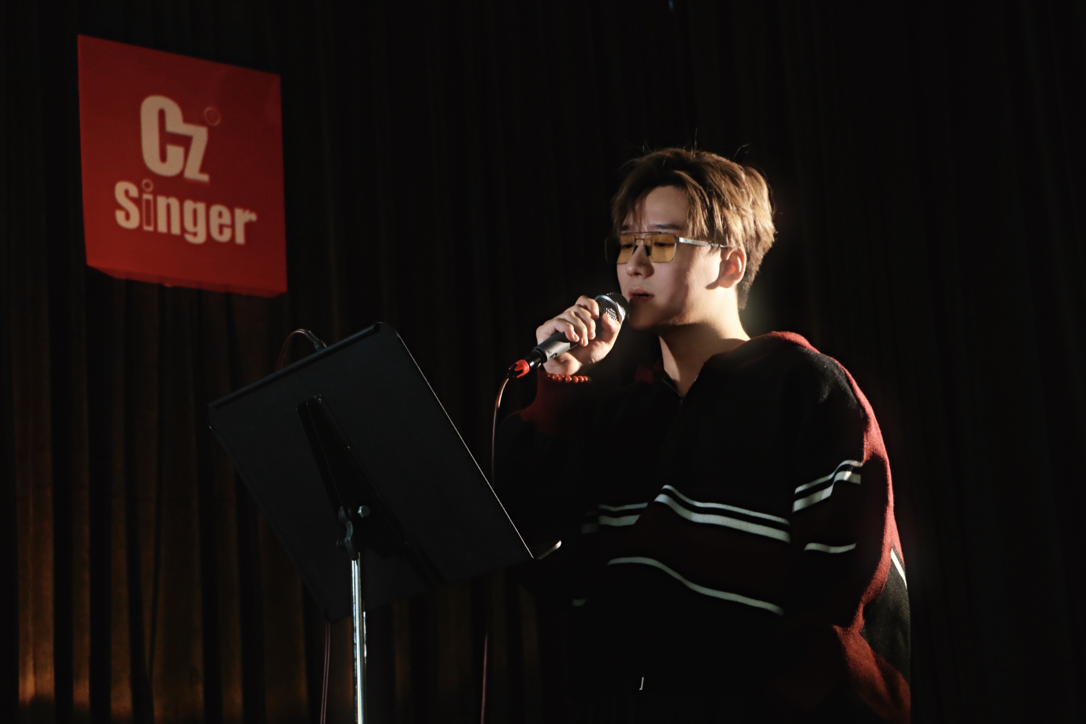 歌者在 CZ Singer 小型现场使用手持麦克风演唱